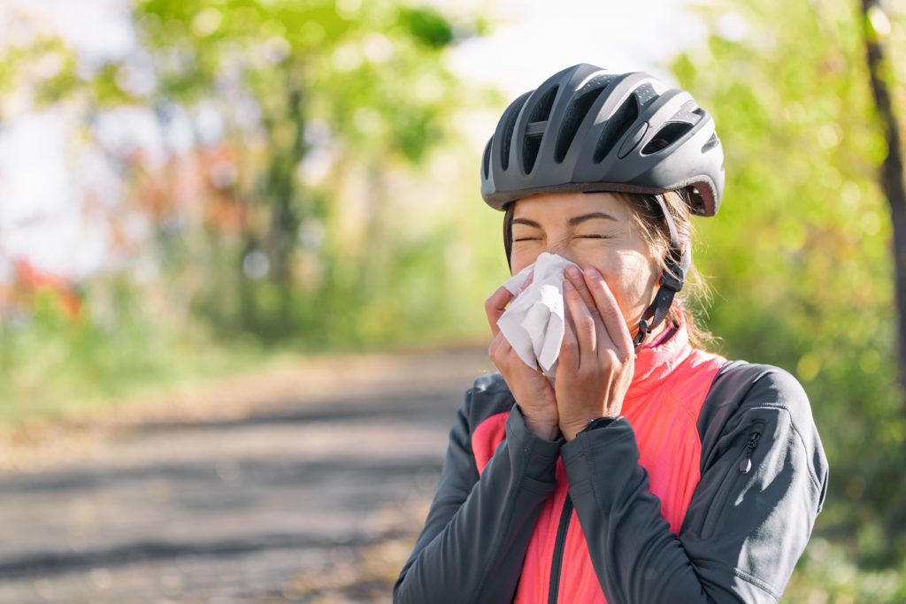 cyclist blowing nose into napkin